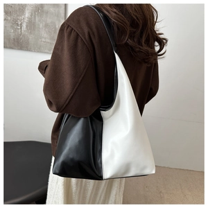 Detail of minimalist black and white leather tote bag styled with an autumn outfit