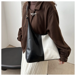Detail of a large capacity tote bag with black and white color blocking and slim straps