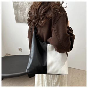 Detail of large black and white contrast leather tote bag showing drape and texture