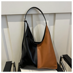 Detail view of the black and brown patchwork tote bag with an adjustable shoulder strap