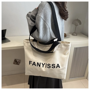 Detail of the durable canvas tote bag featuring FANYISSA logo and dual handle straps
