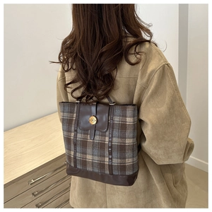 Detailed close-up of vintage plaid tote bag featuring leather trim and N-logo metal buckle