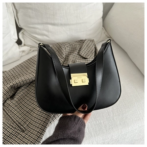 Detail of minimalist black matte leather hobo bag with gold metal buckle closure