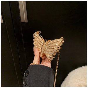 Vue détaillée de la pochette papillon dorée ornée de cristaux scintillants et chaîne