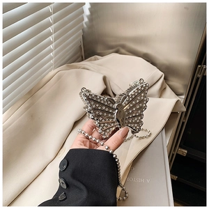Détail du sac de soirée papillon avec strass argentés et chaîne en perles métal
