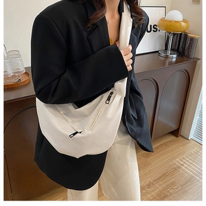 White leather crescent bag on model in black suit for casual chic styling