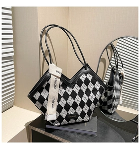 Detail of checkered tote bag featuring a V-shaped opening and stylish ribbon pendant