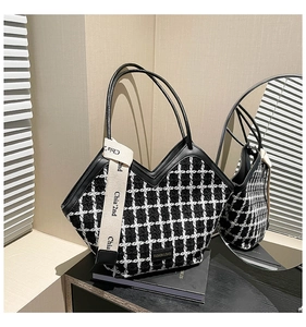 Detail view of black and white tweed tote bag with V-shaped opening and fashion label