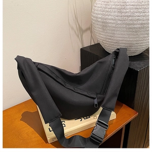 Detail of black nylon crescent crossbody bag with adjustable wide strap and buckle