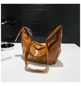 Brown faux leather crescent bag with adjustable shoulder strap and glossy finish