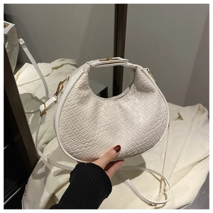 Detail of white woven crescent bag with gold hardware and detachable shoulder strap