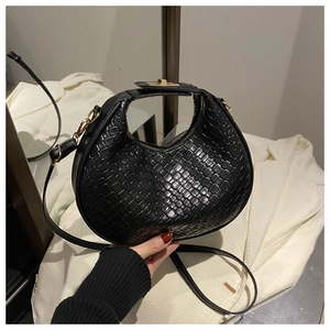 Detail of black woven crescent bag with gold metal twist lock and PU leather texture