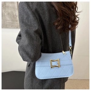 Detailed view of light blue quilted leather shoulder bag with gold hardware buckle
