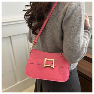 Détail du sac à bandoulière rose matelassé avec fermoir doré et sangle sur un modèle