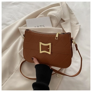 Détail du sac bandoulière matelassé caramel avec fermoir doré et texture à carreaux
