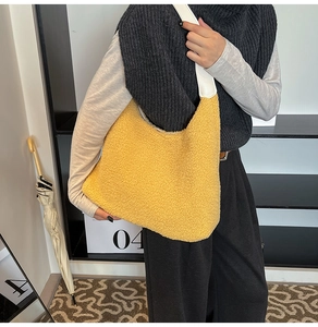 Detailed texture of bright yellow faux shearling plush tote bag with white leather strap