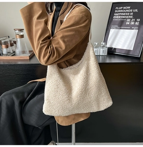 Detail of soft ivory plush hobo bag worn by a model in a warm lifestyle setting
