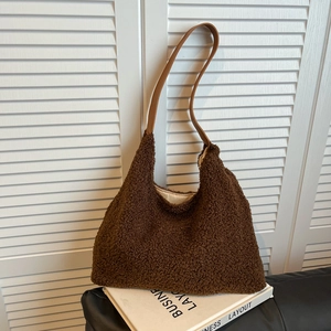 Plush brown faux fur tote bag with leather straps on a minimalist white background