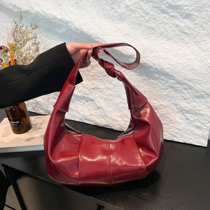 Large burgundy pleated dumpling bag in glossy leather with a stylish knotted shoulder strap