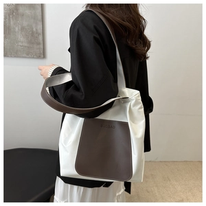 Close-up of minimalist large tote bag with white leather and brown front pocket detail