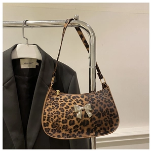 Detail of hobo shoulder bag with leopard print and silver butterfly metallic ornament