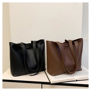 Detail of minimalist black and brown large tote bags made of high-quality smooth faux leather