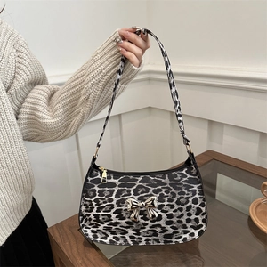 Fashionable leopard print baguette bag with golden metal bow and shoulder strap