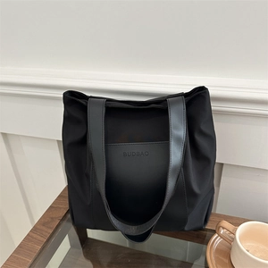 Minimalist black large capacity tote bag with front pocket and shoulder straps for women