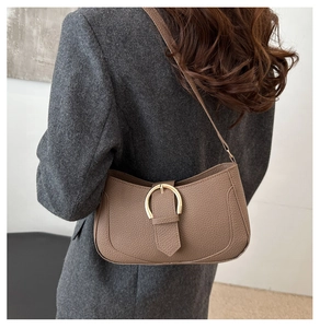 Detail der kaffeebraunen Schultertasche aus Leder mit Litschimuster und Gold-Schnalle