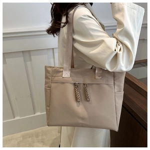 Détails du grand sac cabas beige en toile avec poches latérales et tirettes tissées
