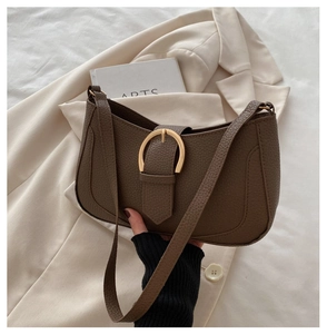 Detail der dunkelbraunen sichelförmigen Tasche mit goldener Hufeisenschnalle