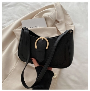 Detailsicht der schwarzen Lederhandtasche mit großer goldener Hufeisenschnalle