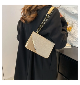 Detail of champagne gold chain bag showing tweed texture and glossy patent leather finish