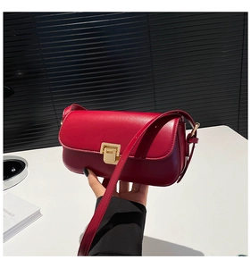 Detail of vintage red square crossbody bag with premium gold metal buckle and smooth leather