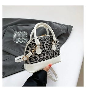 Macro detail of leopard print shell bag with white leather trim and gold zippers