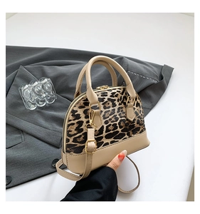 Detail of leopard print patchwork shell bag with smooth beige leather and top handle