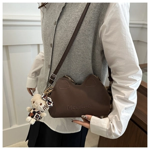 Détail du sac bandoulière marron oreilles de chat avec peluche léopard et pendentif