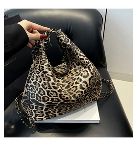 Détail du sac à main léopard avec ferrures dorées et bandoulière en chaîne épaisse