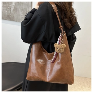 Détail du grand sac cabas marron foncé avec charme d'ours en peluche et foulard rayé