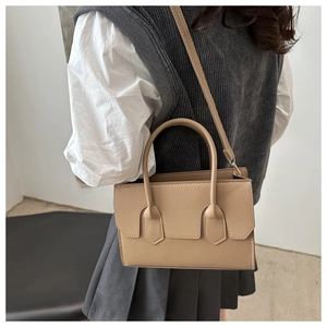 Detailed view of beige crossbody bag showing sleek structure and fine stitching