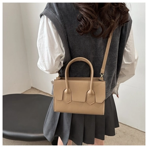 Minimalist khaki crossbody bag shown with chic outfit in a stylish indoor setting