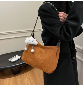 Détail du sac cabas en daim marron avec bandoulière en chaîne et breloque nuage en peluche