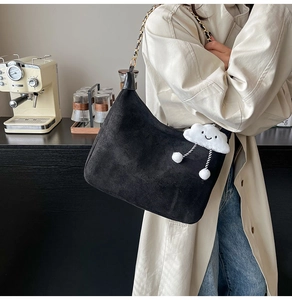 Détail du sac hobo en daim noir avec bandoulière en chaîne et pendentif nuage blanc