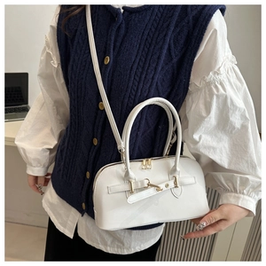 Detail of white PU leather Boston bag with gold horsebit buckle and adjustable strap