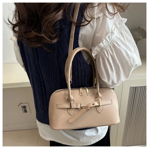 Detail showing the apricot PU leather tote with gold hardware on a model's arm
