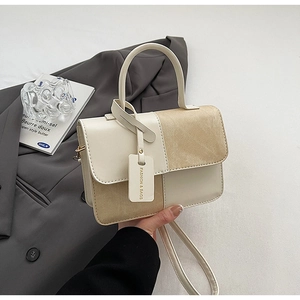 Detail of mixed-texture contrast handbag with suede panel and FASHION & BAGS tag