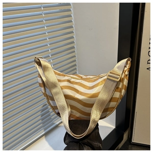 Detail of yellow and white striped crescent bag with adjustable wide fabric shoulder strap