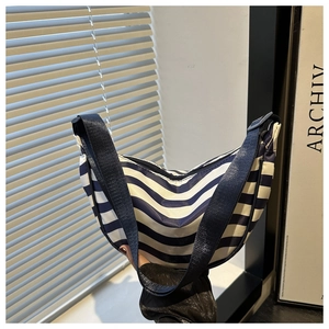 Détail du sac demi-lune à rayures bleues et blanches avec bandoulière et fermeture éclair