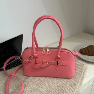 Bright pink faux leather bowling handbag with double handles and adjustable shoulder strap