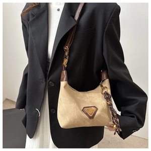 Détail du sac cabas rétro en toile avec garniture en cuir marron et logo sur un mannequin